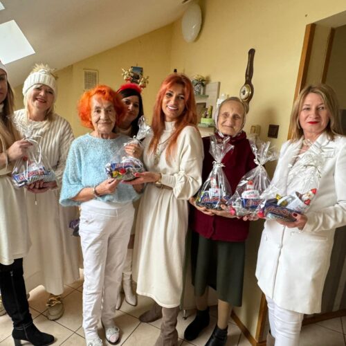 Opiekunowie z mieszkańcami DPS prezentują podarunki